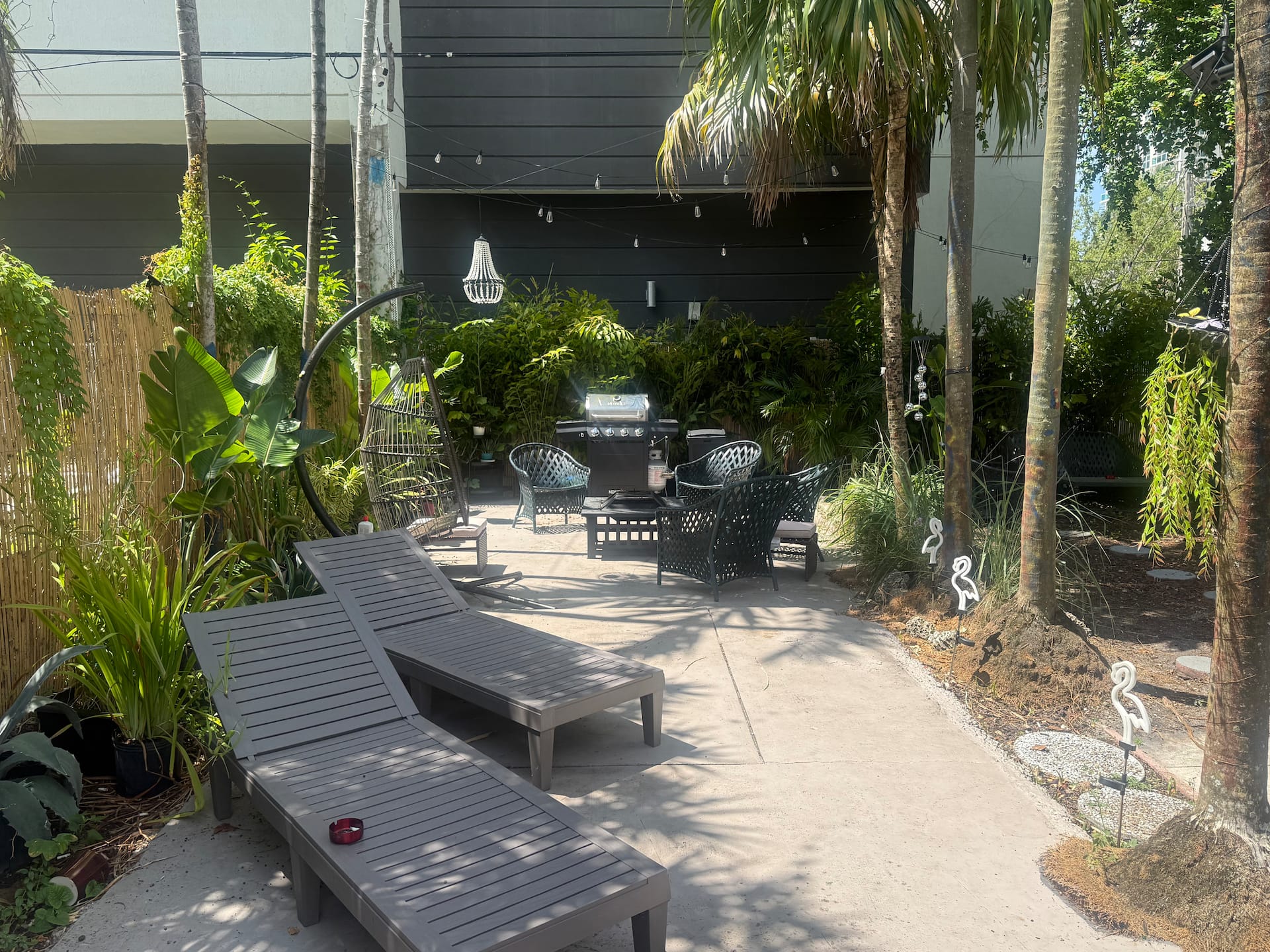 A sunlit garden patio surrounded by tropical greenery at Biscayne Hideaway